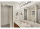 Bright bathroom featuring a double vanity, large mirror, and an open closet at 8116 Barksdale Way, Indianapolis, IN 46216