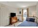 Bedroom featuring blue bedspread, window, curtains, wall decor, and a dresser at 8116 Barksdale Way, Indianapolis, IN 46216