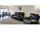 Inviting living room features comfortable seating, neutral carpet, and a dining area by the sliding glass door at 8116 Barksdale Way, Indianapolis, IN 46216
