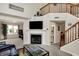 Spacious living room featuring a cozy fireplace, stairs to the second floor, and modern decor elements at 8116 Barksdale Way, Indianapolis, IN 46216