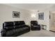 Living room with leather sofa and chair set, neutral carpet, and artwork on the walls at 8116 Barksdale Way, Indianapolis, IN 46216
