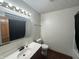 Bright bathroom featuring a vanity with ample lighting, a toilet, and a shower with a black curtain at 82 Pin Oak Ct, Whiteland, IN 46184