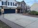 Traditional two-story home with dark blue garage door, brick walkway, and blooming tree in the front yard at 82 Pin Oak Ct, Whiteland, IN 46184