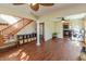 Spacious living room with wood floors, wood stairs, ceiling fans, and view into kitchen at 82 Pin Oak Ct, Whiteland, IN 46184