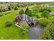Aerial view of a brick home showcasing its extensive yard, driveway, and surrounding greenery at 8362 N County Road 650 E, Brownsburg, IN 46112