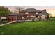 Brick home backyard with a patio, outdoor seating, manicured lawn, and lush landscaping at 8362 N County Road 650 E, Brownsburg, IN 46112