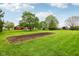 Manicured backyard features a dedicated garden plot and distant views of a home with brickwork at 8362 N County Road 650 E, Brownsburg, IN 46112