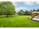 Expansive backyard featuring a stone patio, mature trees, and professionally landscaped garden bed at 8362 N County Road 650 E, Brownsburg, IN 46112
