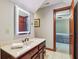 Cozy bathroom with a backlit mirror, wood vanity, and an open doorway to the next room at 8362 N County Road 650 E, Brownsburg, IN 46112