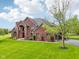 Elegant brick home featuring a lush green lawn, attached garage, and circular driveway at 8362 N County Road 650 E, Brownsburg, IN 46112