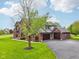 Beautiful brick home featuring a three-car garage and meticulously landscaped front yard with healthy green grass at 8362 N County Road 650 E, Brownsburg, IN 46112