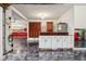 Garage with epoxy floor, white cabinets, and view into a garage/workshop with racing decals at 8362 N County Road 650 E, Brownsburg, IN 46112