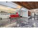 Expansive garage with epoxy floor, wood ceiling, work area, and stainless steel refrigerator at 8362 N County Road 650 E, Brownsburg, IN 46112