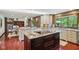 Open kitchen with granite countertops, dark island, and hardwood floors offer a great space for entertaining at 8362 N County Road 650 E, Brownsburg, IN 46112