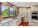Bright kitchen features granite countertops, stainless appliances, and a large window overlooking a lush yard at 8362 N County Road 650 E, Brownsburg, IN 46112