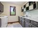 Well-organized laundry room with gray cabinets, marble countertops, stylish tile flooring, and window to the outside at 8362 N County Road 650 E, Brownsburg, IN 46112
