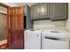 Laundry room featuring gray cabinets, stainless steel sink, and a modern white washer and dryer set at 8362 N County Road 650 E, Brownsburg, IN 46112