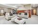 Bright living room featuring neutral walls and carpet, stylish couches and chairs, wood trim, and pool table in background at 8362 N County Road 650 E, Brownsburg, IN 46112