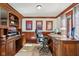 Well-appointed home office featuring wood paneling, custom built-ins, and a professional workspace at 8362 N County Road 650 E, Brownsburg, IN 46112