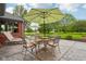 Outdoor seating area with a table, chairs, umbrella, and a view of the well-maintained lawn and landscaping at 8362 N County Road 650 E, Brownsburg, IN 46112