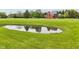 Scenic view of a tranquil pond with a reflection of the red brick house, surrounded by a lush green lawn at 8362 N County Road 650 E, Brownsburg, IN 46112