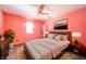 Bright bedroom features pink walls, a ceiling fan, a wood dresser, and a matching nightstand at 9056 E 650 N, Wilkinson, IN 46186