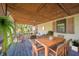 Inviting covered porch with seating, dining area, and lush greenery at 9056 E 650 N, Wilkinson, IN 46186