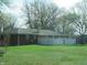 View of a large fenced backyard with a brick house and mature trees at 9113 Church Rd, Brownsburg, IN 46112