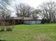 View of a fenced backyard with a brick house and mature trees at 9113 Church Rd, Brownsburg, IN 46112