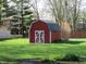 View of a new red and white utility shed in the backyard at 9113 Church Rd, Brownsburg, IN 46112