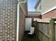 Narrow space in backyard with white door, fence and chair at 914 Baden Manor Dr, Indianapolis, IN 46217