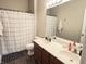 Well-lit bathroom featuring a double vanity, updated fixtures, and a shower with a black and white patterned curtain at 914 Baden Manor Dr, Indianapolis, IN 46217