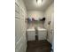 Functional laundry room with a full-size washer and dryer set and ample storage shelving at 914 Baden Manor Dr, Indianapolis, IN 46217