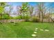 Spacious backyard with a lush green lawn, mature trees, and a wooden fence offers plenty of space to relax at 9531 Charter Dr, Indianapolis, IN 46250