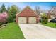 Brick home with a two-car garage and a wide driveway surrounded by lush green grass and landscaping at 9531 Charter Dr, Indianapolis, IN 46250