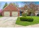 Attractive brick home featuring a two-car garage and a vibrant green lawn with mature trees at 9531 Charter Dr, Indianapolis, IN 46250