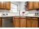 A well-lit kitchen features oak cabinetry and granite countertops with stainless steel dishwasher at 9531 Charter Dr, Indianapolis, IN 46250