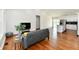 Spacious living room featuring wood floors, a comfortable sofa, and an open layout connecting to the kitchen at 1018 N 18Th St, Elwood, IN 46036