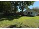 Spacious backyard featuring a lush lawn, mature trees, and a quaint home exterior at 1032 Groff Ave, Indianapolis, IN 46222