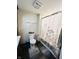 Bright bathroom showcasing stylish decor, toilet, and a floral shower curtain at 1117 Hendricks Ave, Shelbyville, IN 46176