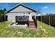 Exterior view of the home showcasing the deck, well-kept lawn, and wooden fence at 1117 Hendricks Ave, Shelbyville, IN 46176