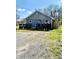 Exterior view of home featuring gray siding, black deck, and gravel driveway at 1117 Hendricks Ave, Shelbyville, IN 46176