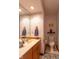 Cozy bathroom featuring floral wallpaper, a vanity with sink, and a toilet at 11203 Westminster Way, Carmel, IN 46033