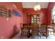 Elegant dining room with red accent wall, chandelier, and classic wooden furniture at 11203 Westminster Way, Carmel, IN 46033