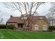 Charming stone home featuring a manicured lawn, a welcoming entryway, and a new roof at 11203 Westminster Way, Carmel, IN 46033