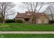 Charming stone home featuring a manicured lawn, a welcoming entryway, and a new roof at 11203 Westminster Way, Carmel, IN 46033