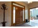 Warm and inviting foyer with a wooden front door, patterned rug, and coat rack at 11203 Westminster Way, Carmel, IN 46033