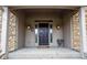 Welcoming covered front porch with double doors, sconces, and stone accents at 11203 Westminster Way, Carmel, IN 46033