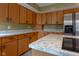 Open kitchen features natural wood cabinets with marble countertop, plus stainless refrigerator at 11203 Westminster Way, Carmel, IN 46033