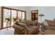 Inviting living room with plush sofa, natural light, and views of the outdoor deck at 11203 Westminster Way, Carmel, IN 46033